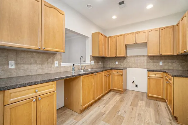a kitchen with stainless steel appliances granite countertop a sink and cabinets