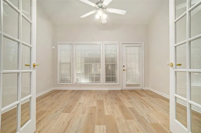 a view of an empty room with wooden floor and a window