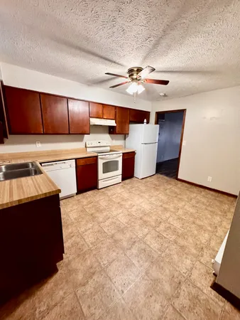 a large kitchen with stainless steel appliances a large counter top