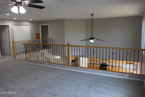an empty room with windows and fan