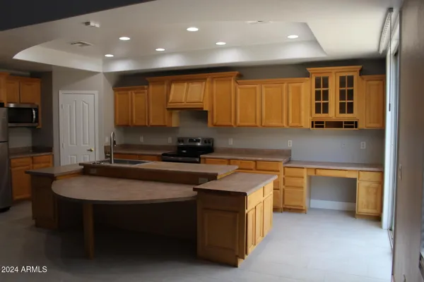 a kitchen with stainless steel appliances granite countertop a sink a stove and a refrigerator
