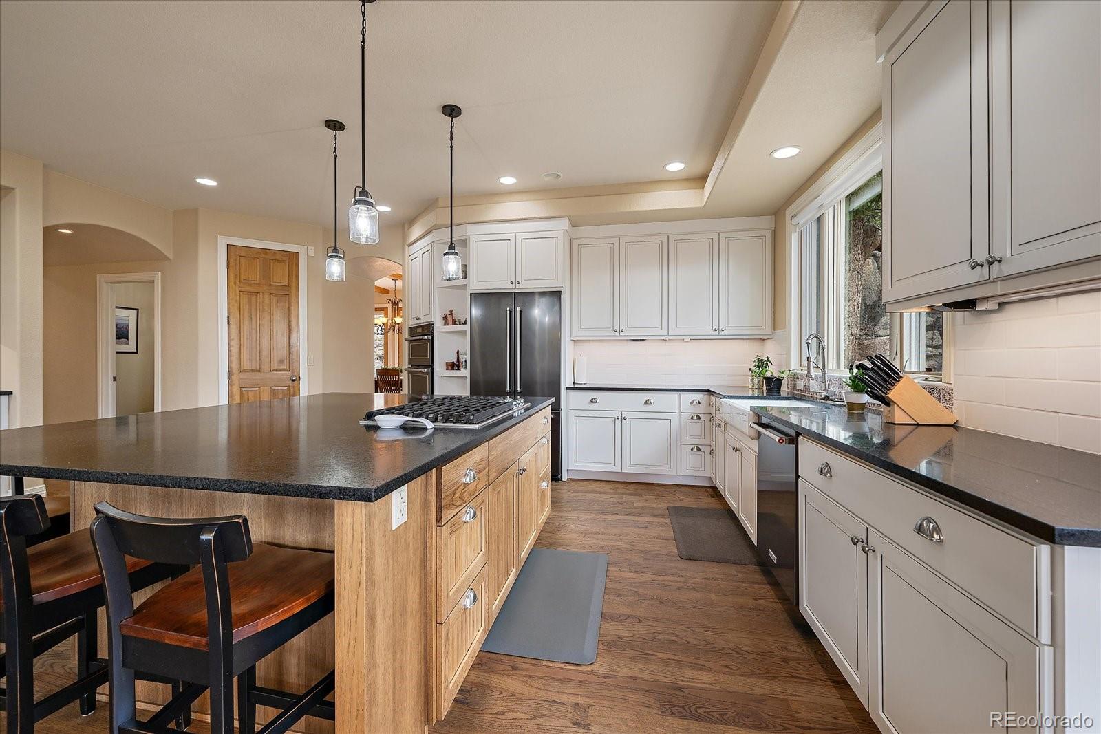 6737 Timbers Drive Evergreen, CO 80439 - Photo 13 of 47 a kitchen with kitchen island granite countertop lots of counter top space and sink