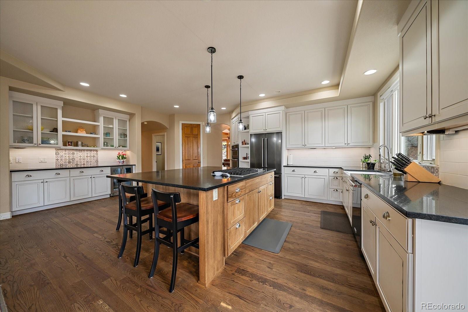 6737 Timbers Drive Evergreen, CO 80439 - Photo 14 of 47 a large kitchen with kitchen island a sink table and chairs