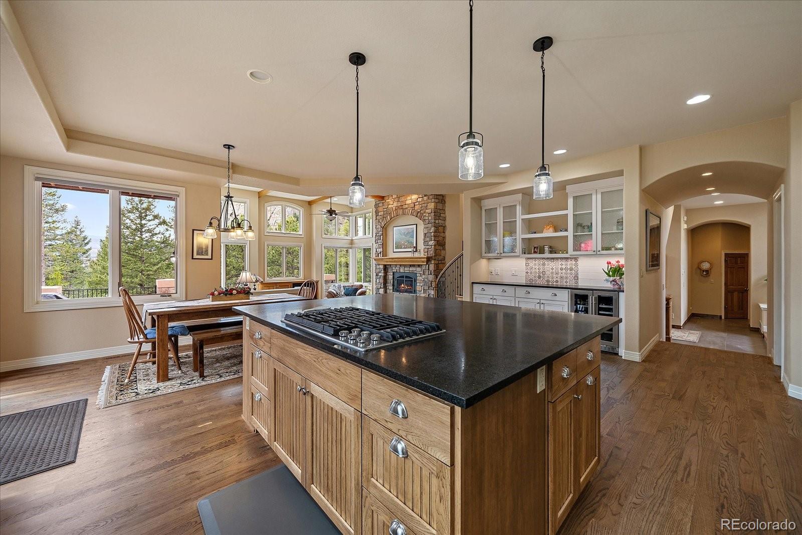 6737 Timbers Drive Evergreen, CO 80439 - Photo 15 of 47 a kitchen with stainless steel appliances granite countertop a stove a sink and a wooden floors