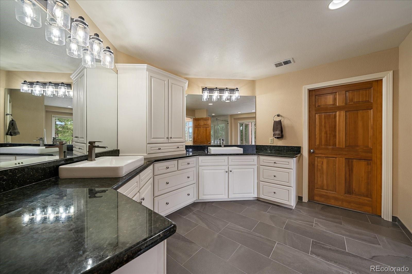 6737 Timbers Drive Evergreen, CO 80439 - Photo 25 of 47 a large bathroom with double vanity and a mirror