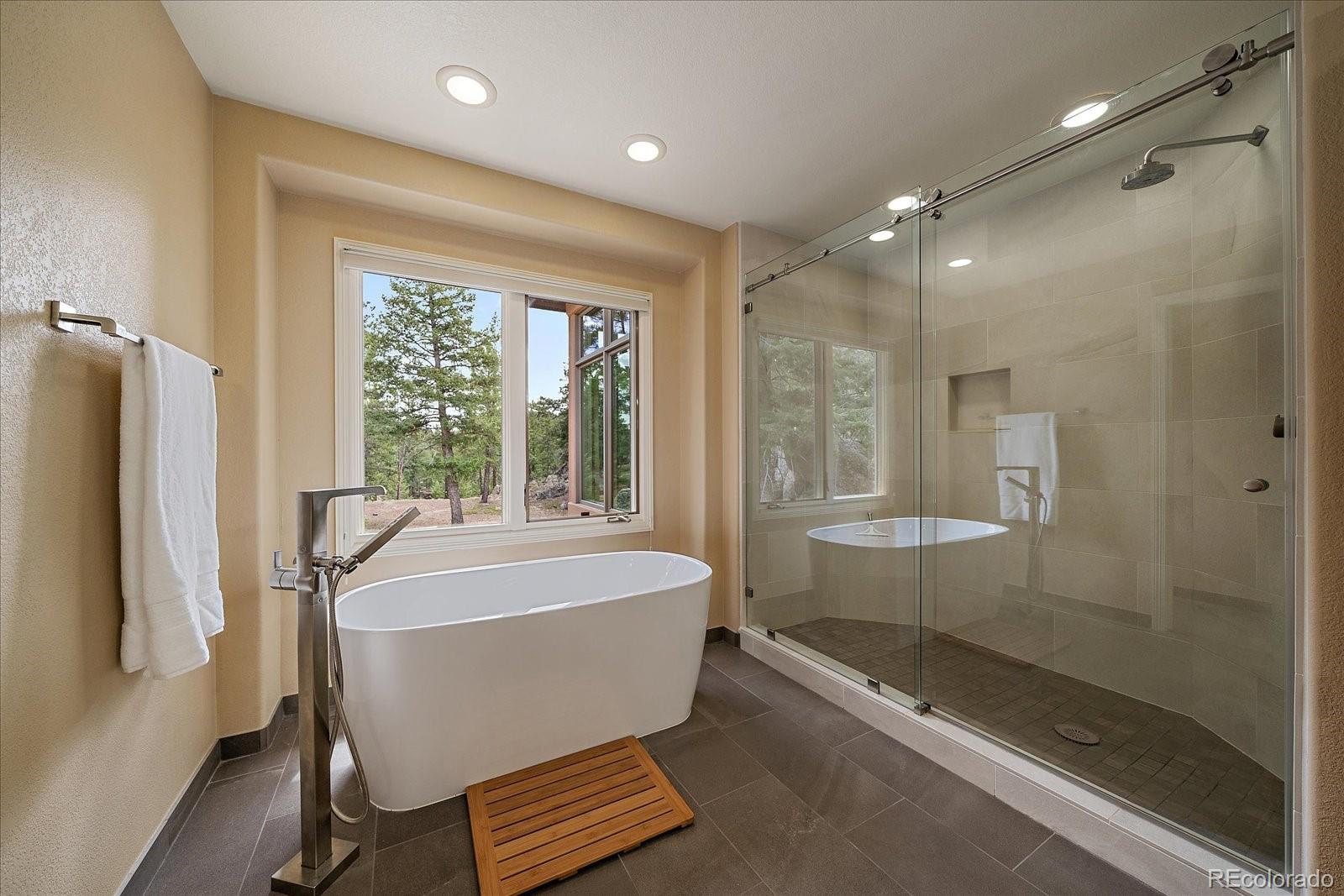 6737 Timbers Drive Evergreen, CO 80439 - Photo 26 of 47 a bathroom with a bathtub and a shower