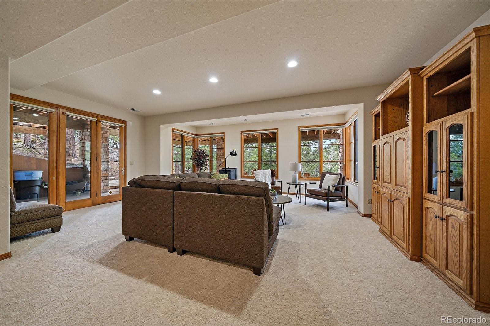 6737 Timbers Drive Evergreen, CO 80439 - Photo 32 of 47 a living room with furniture and a flat screen tv