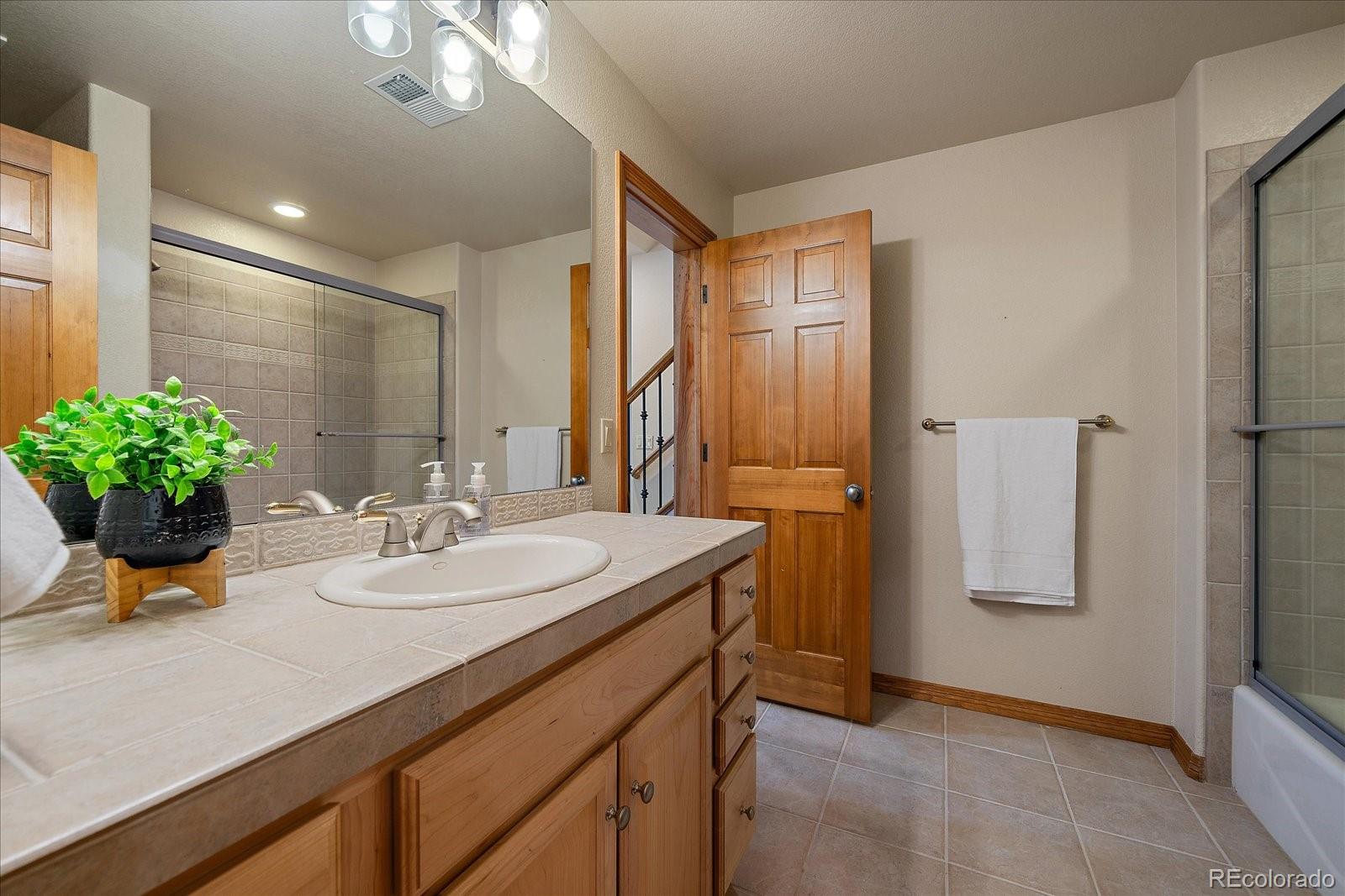 6737 Timbers Drive Evergreen, CO 80439 - Photo 35 of 47 a bathroom with a sink a mirror and a shower
