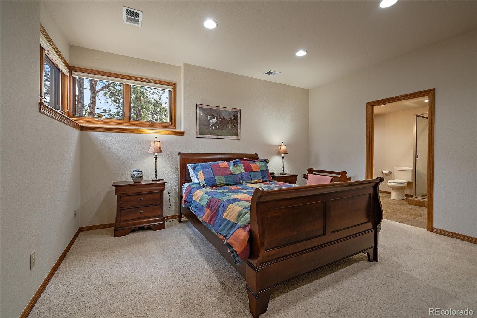 6737 Timbers Drive Evergreen, CO 80439 - Photo 36 of 47 a bedroom with a bed lamp and a window