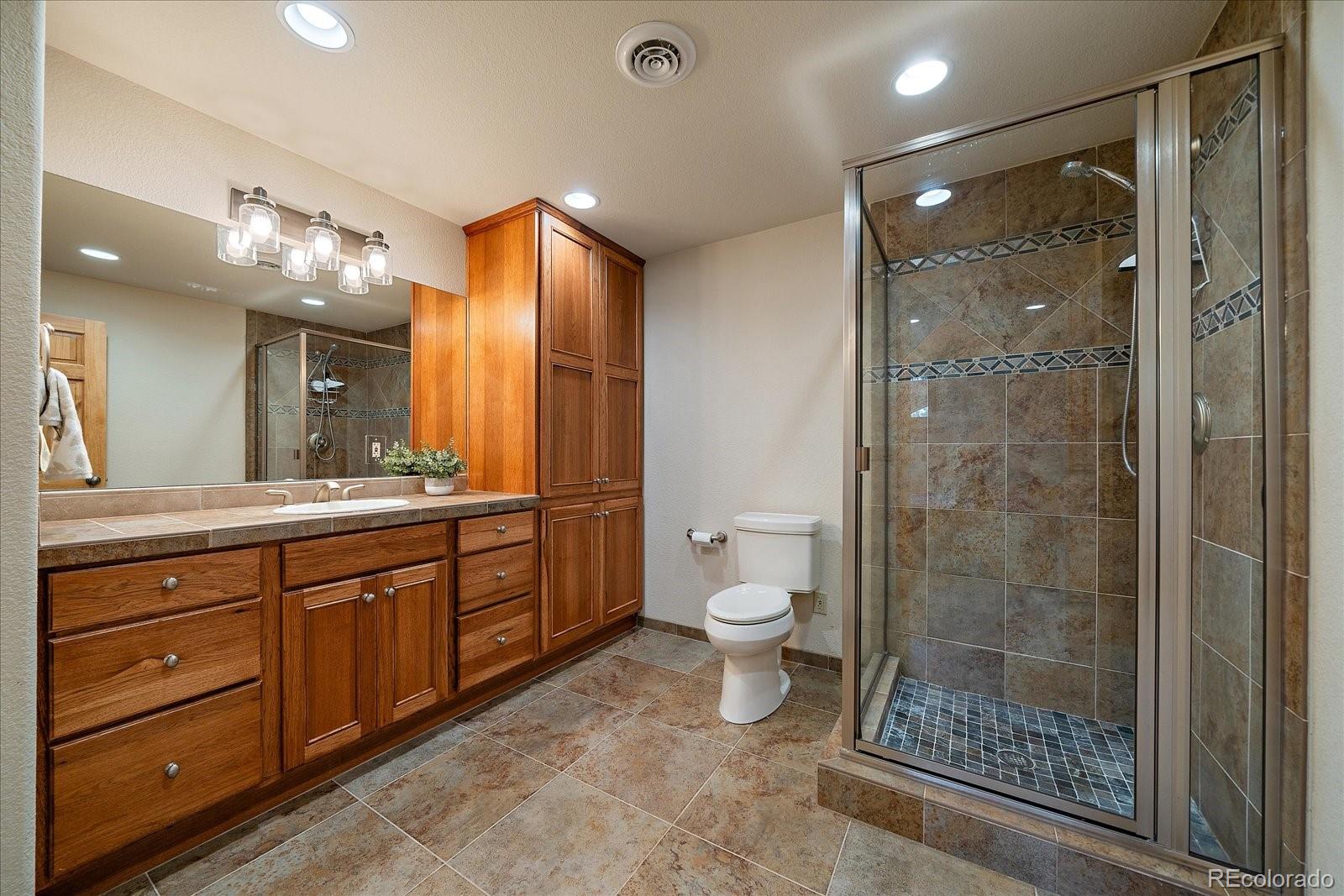 6737 Timbers Drive Evergreen, CO 80439 - Photo 37 of 47 a bathroom with a double vanity sink toilet and shower