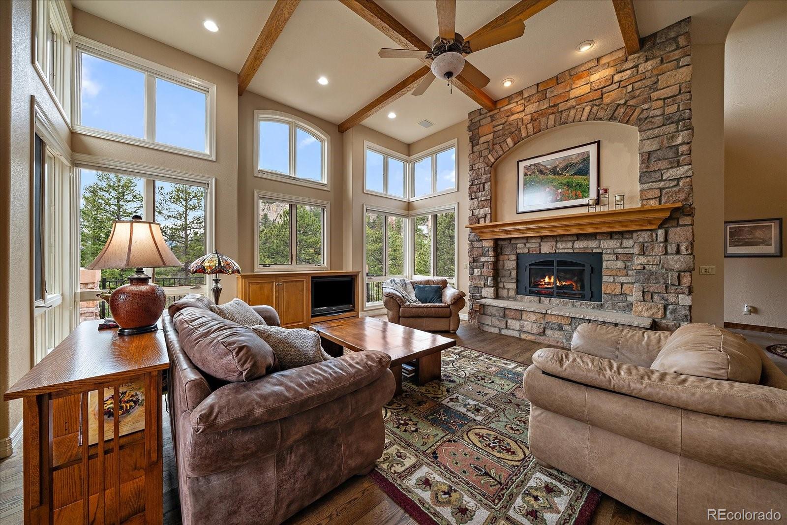 6737 Timbers Drive Evergreen, CO 80439 - Photo 7 of 47 a living room with furniture fireplace and a large window