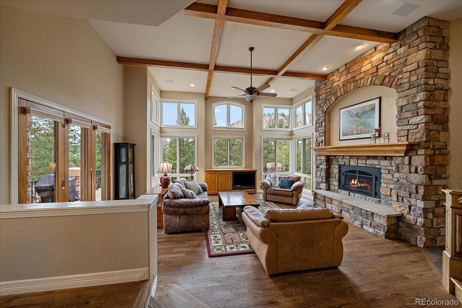 6737 Timbers Drive Evergreen, CO 80439 - Photo 8 of 47 a living room with furniture large windows and a fireplace