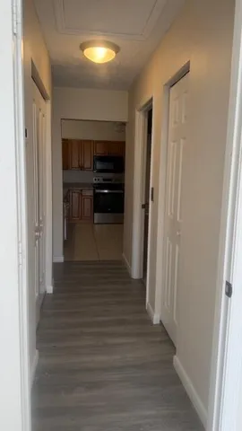a view of entryway and hall with wooden floor