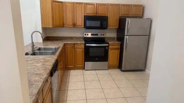 a kitchen with a refrigerator sink and cabinets