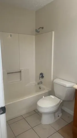 a white toilet and tub sitting next to a bathroom sink