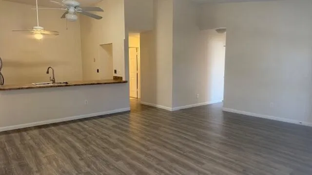 a view of a livingroom with wooden floor and a ceiling fan