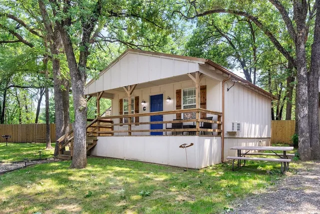 a view of a house with backyard and a tree