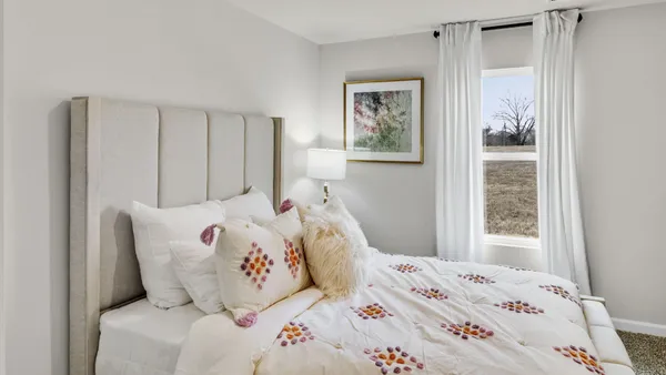 a bedroom with a bed and a mirror on dresser