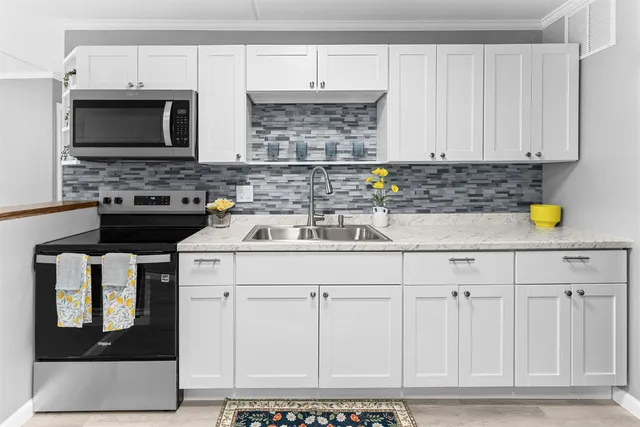 a kitchen with a sink cabinets and stainless steel appliances