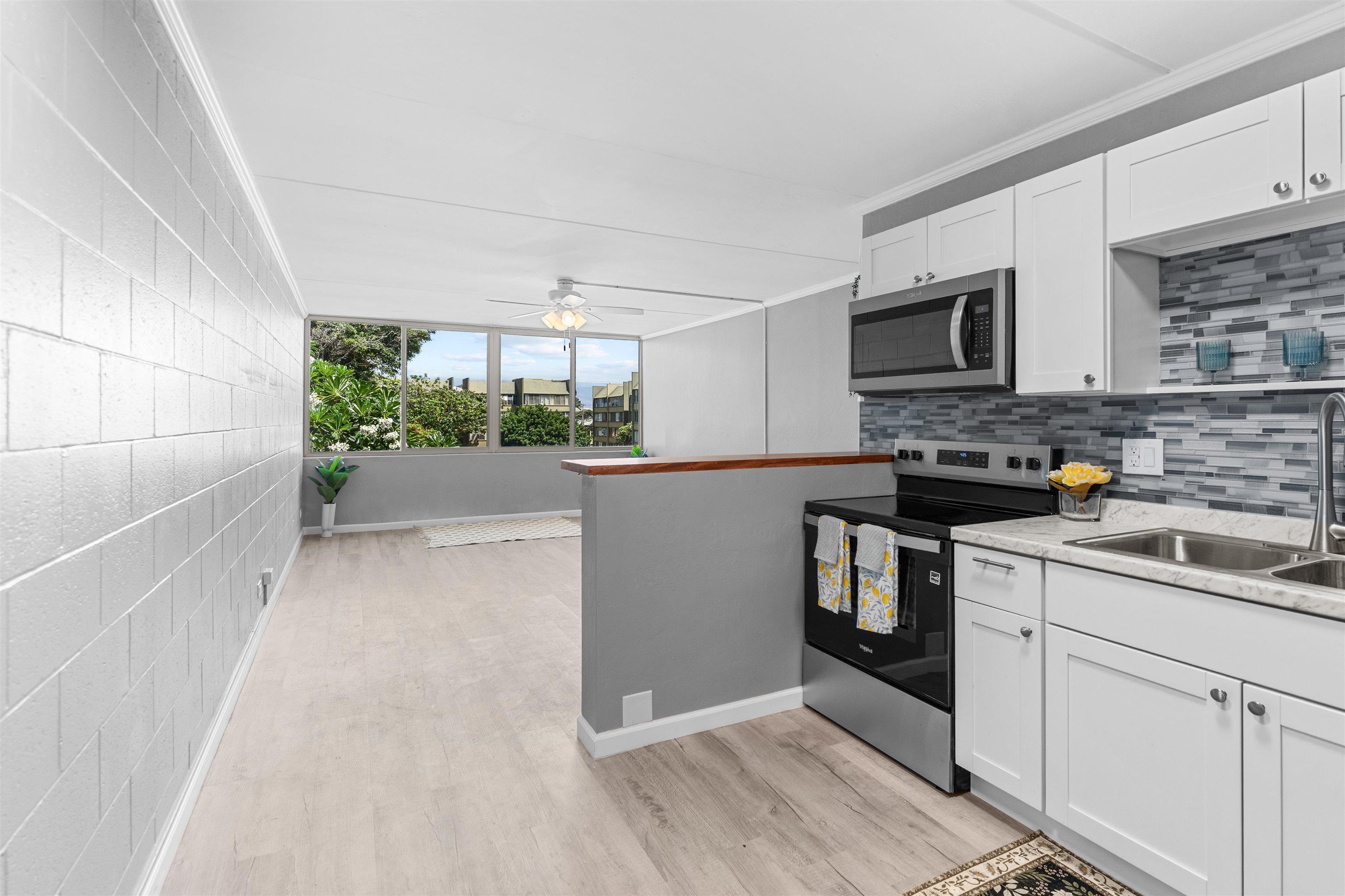 111 Kahului Beach Road, Unit D309 Kahului, HI 96732 - Photo 4 of 26 a kitchen with stainless steel appliances a stove a microwave a sink and cabinets