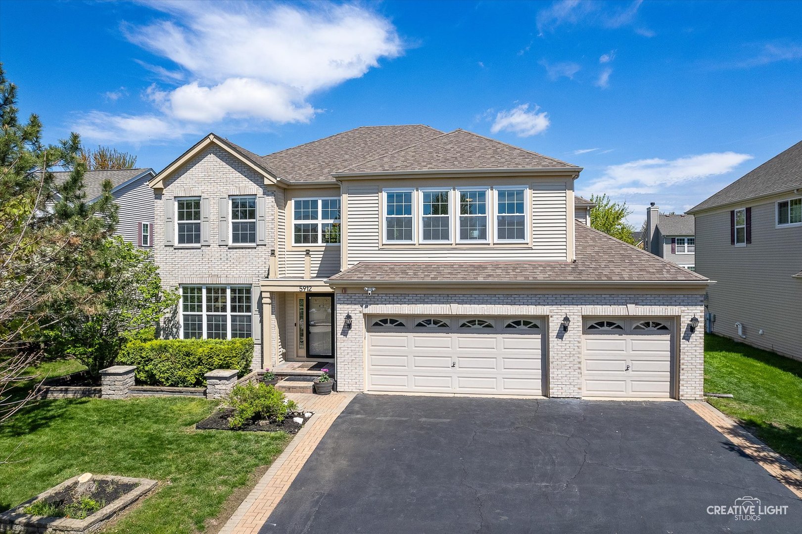 5912 Mackinac Lane Hoffman Estates, IL 60192 - Photo 2 of 32 a front view of a house with a yard and garage