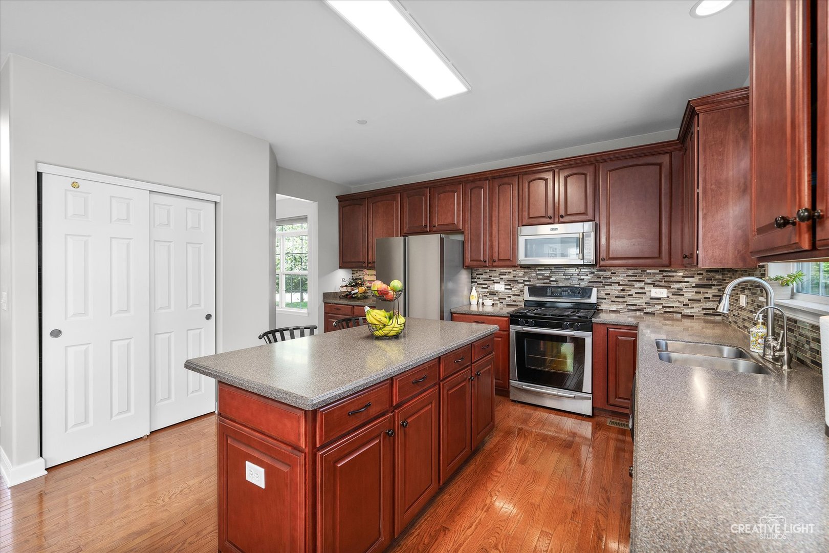 5912 Mackinac Lane Hoffman Estates, IL 60192 - Photo 9 of 32 a kitchen with stainless steel appliances granite countertop a stove top oven a sink dishwasher and a refrigerator with wooden floor