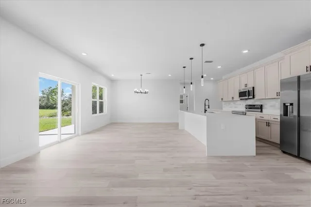 a kitchen with stainless steel appliances a refrigerator sink and microwave