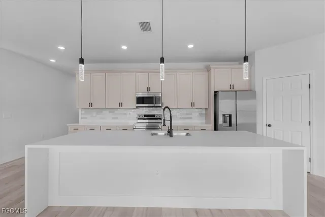 a kitchen with stainless steel appliances a refrigerator sink and microwave