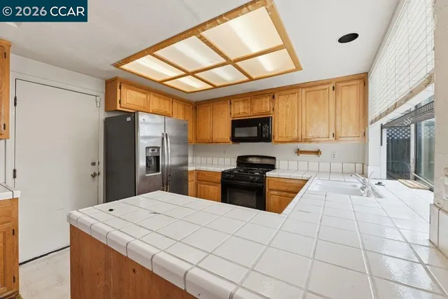 a kitchen with stainless steel appliances granite countertop a refrigerator and a stove
