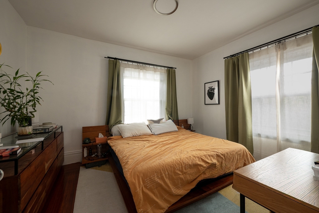 11 Wayne Street Boston, MA 02121 - Photo 24 of 27 a bedroom with a bed and a table in it