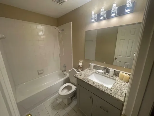 a bathroom with a granite countertop sink a toilet and shower