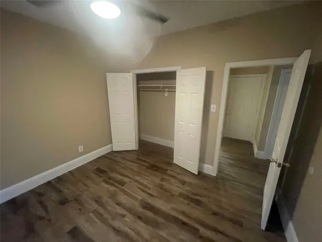 an empty room with wooden floor and closet