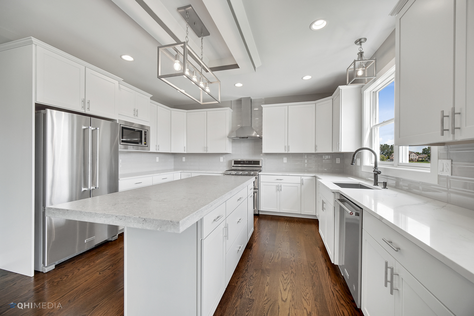 8233 Castle Drive Munster, IN 46321 - Photo 4 of 19 a kitchen with stainless steel appliances granite countertop a sink a stove top oven a refrigerator with white cabinets and wooden floor