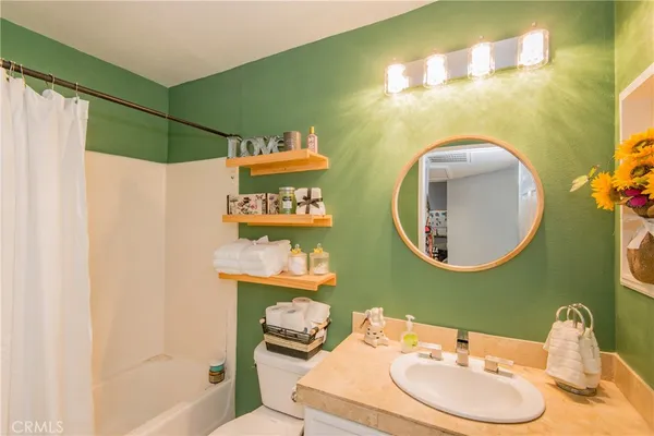 a bathroom with a sink mirror and toilet