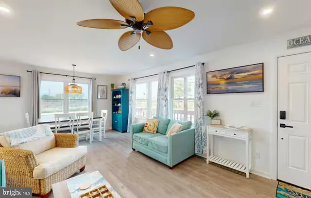 a living room with furniture kitchen view and a large window