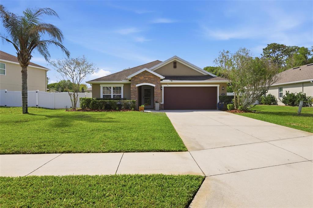 656 Carya Court DeLand, FL 32724 - Photo 1 of 28 a front view of a house with a yard and garage