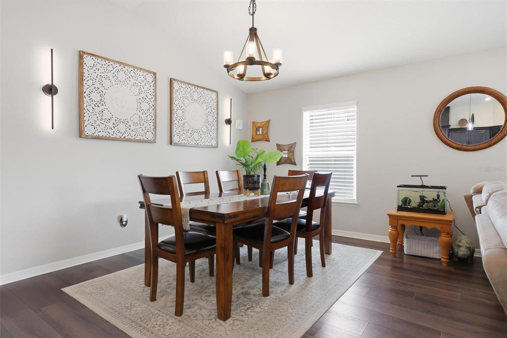 656 Carya Court DeLand, FL 32724 - Photo 11 of 28 a view of a dining room with furniture window and wooden floor
