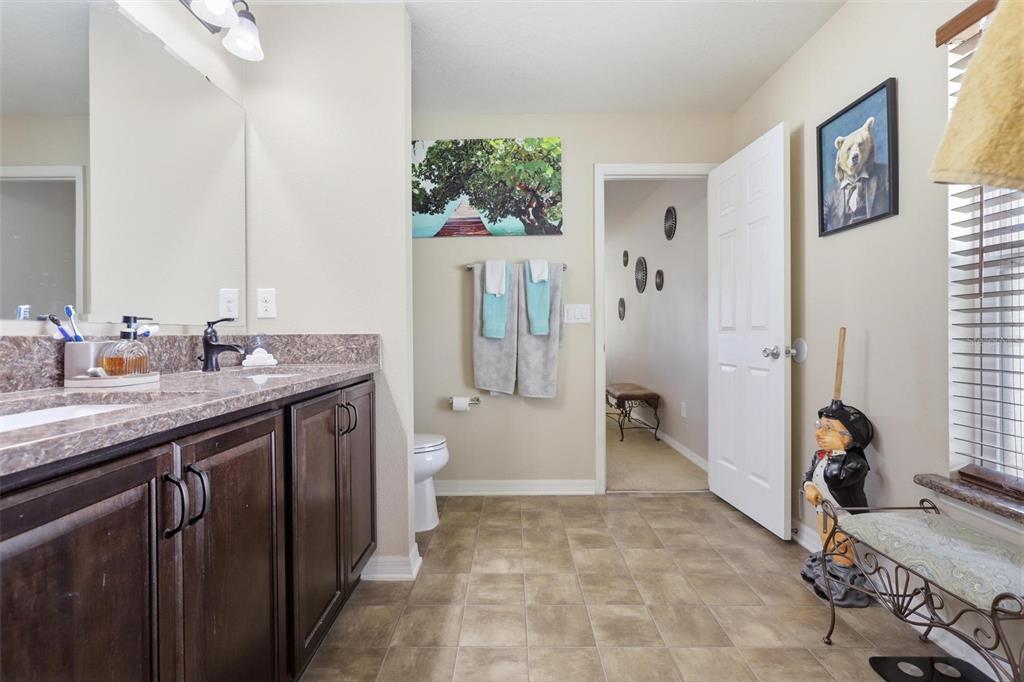 656 Carya Court DeLand, FL 32724 - Photo 15 of 28 a spacious bathroom with a granite countertop sink and a mirror