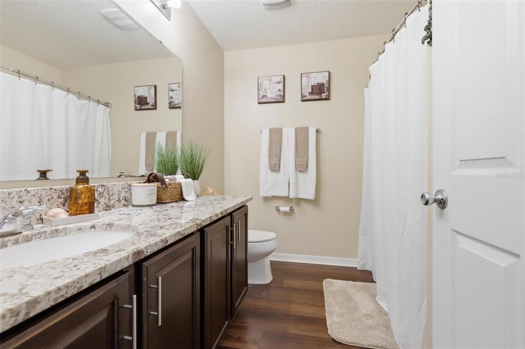 656 Carya Court DeLand, FL 32724 - Photo 18 of 28 a bathroom with a granite countertop sink and a mirror
