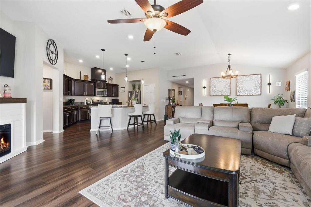 656 Carya Court DeLand, FL 32724 - Photo 6 of 28 a living room with fireplace furniture and a wooden floor