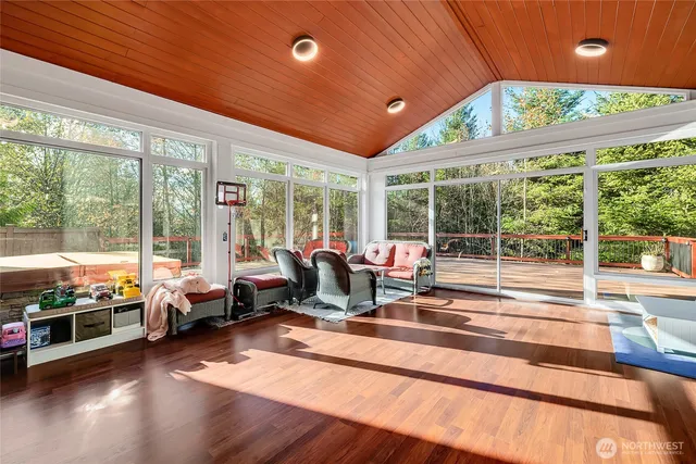a living room with patio furniture and floor to ceiling windows