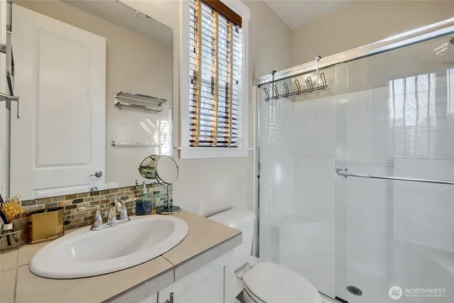 a bathroom with a sink toilet a mirror and shower