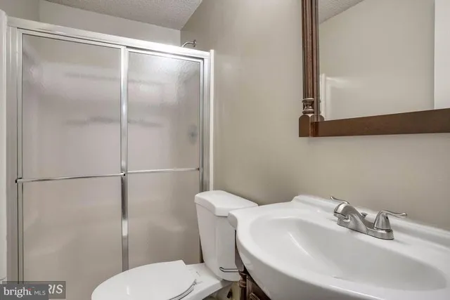 a bathroom with a sink toilet and a mirror