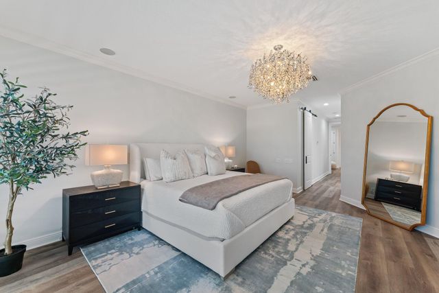 a bedroom with bed and a chandelier