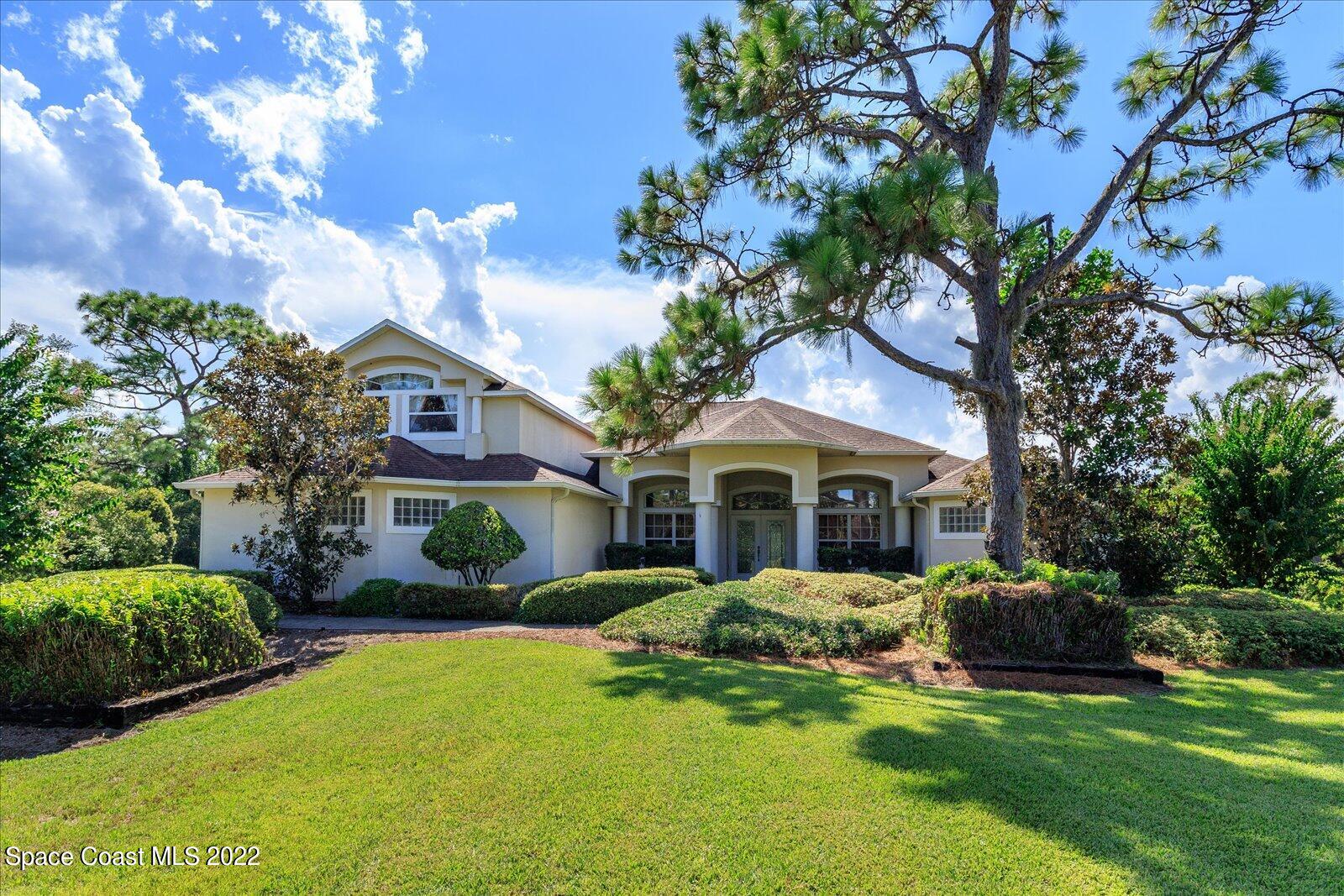3720 Pine Cone Road Melbourne, FL 32934 - Photo 1 of 34 a front view of a house with a garden and trees