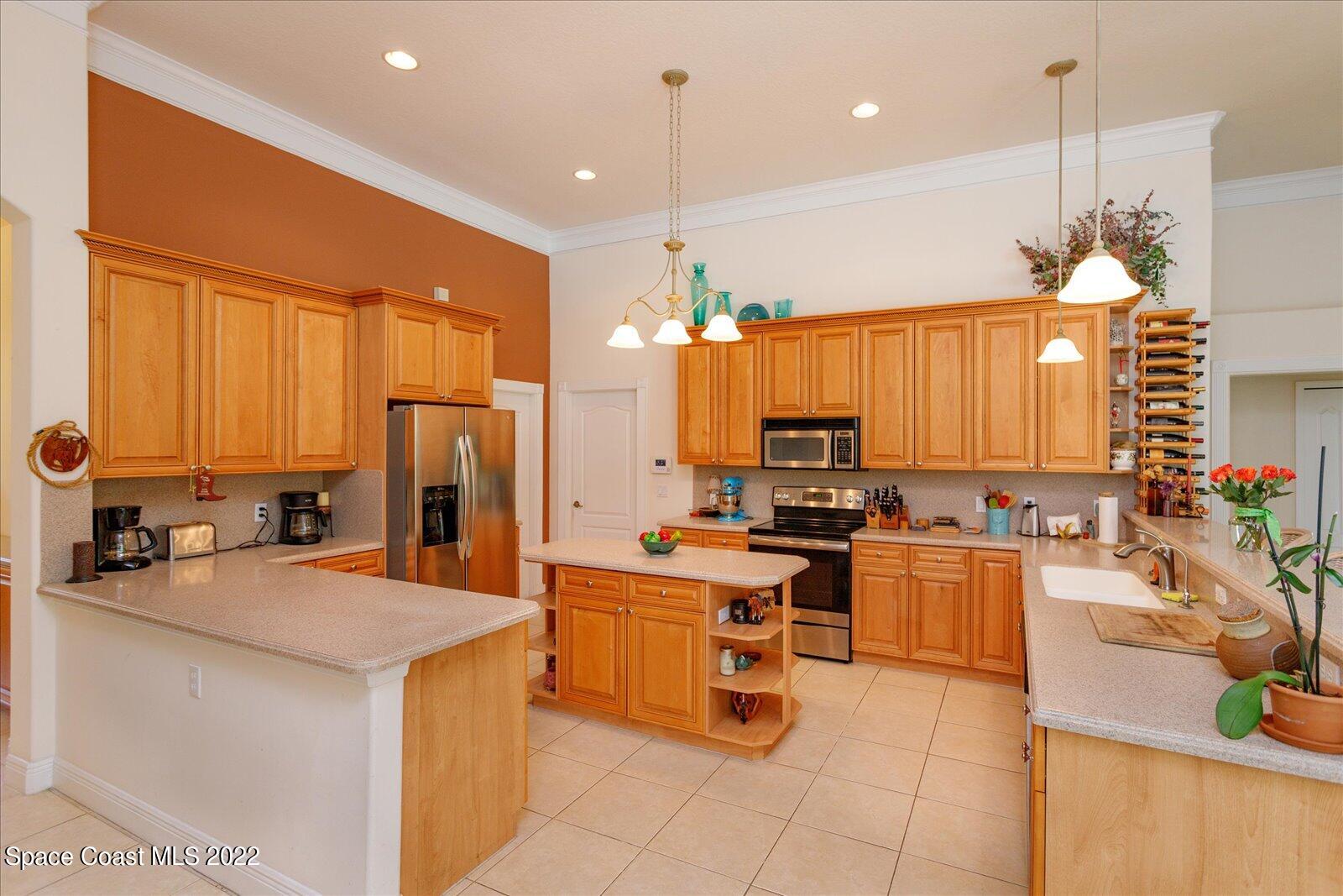 3720 Pine Cone Road Melbourne, FL 32934 - Photo 15 of 34 a kitchen with stainless steel appliances kitchen island granite countertop a sink counter space and a view of living room