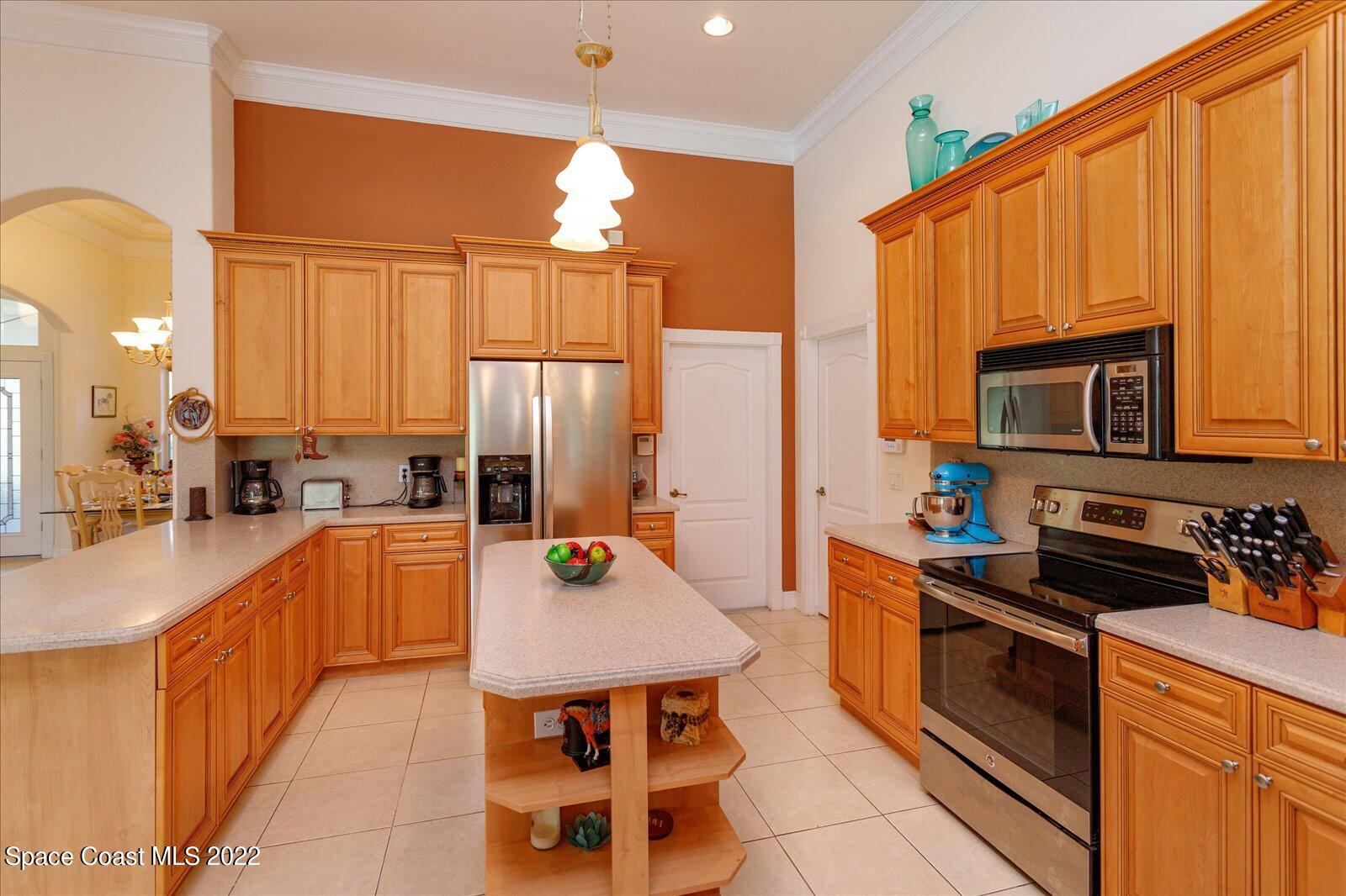 3720 Pine Cone Road Melbourne, FL 32934 - Photo 17 of 34 a kitchen with stainless steel appliances a stove a sink and a refrigerator