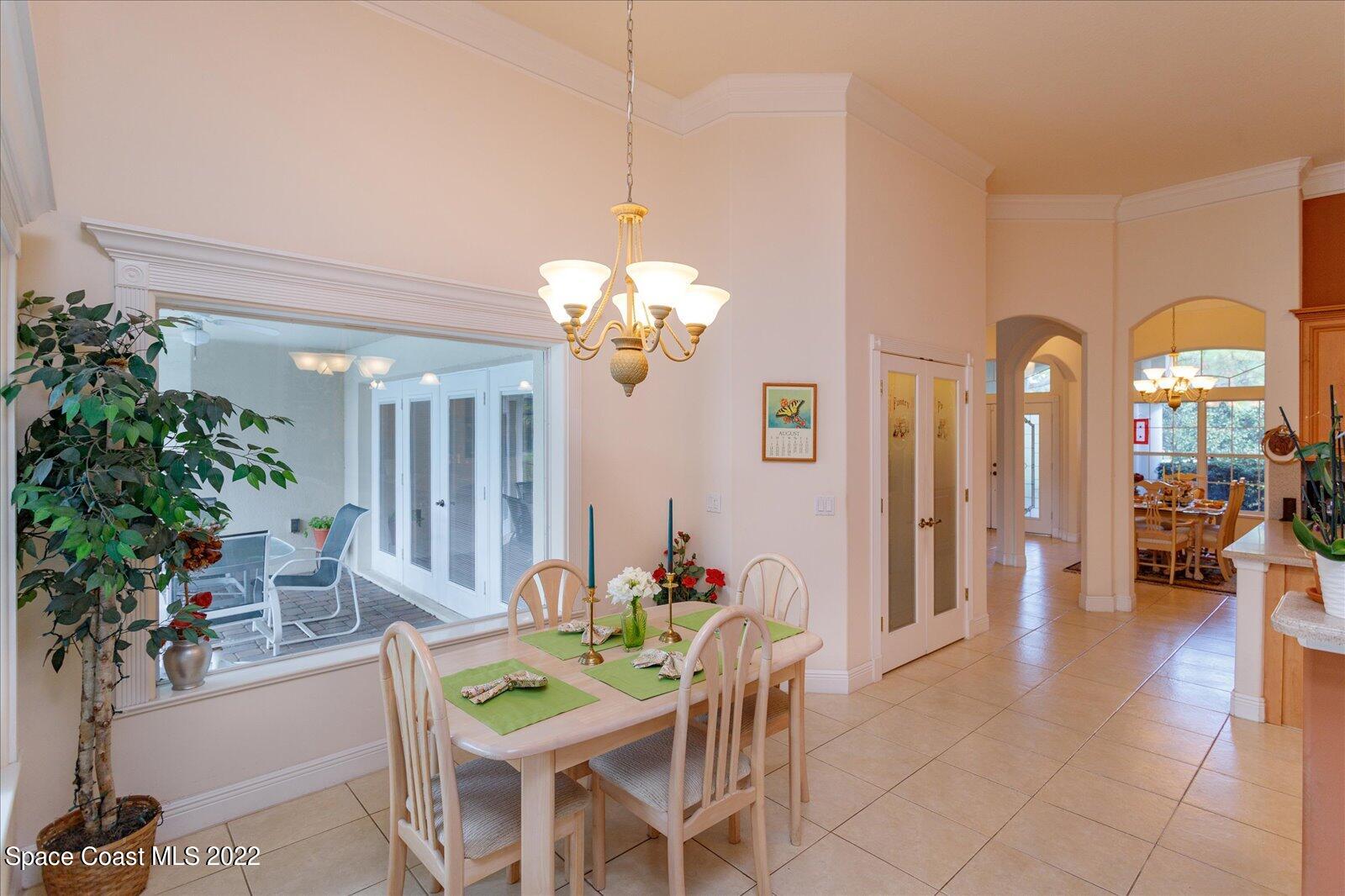 3720 Pine Cone Road Melbourne, FL 32934 - Photo 19 of 34 a view of a dining room with furniture and a chandelier