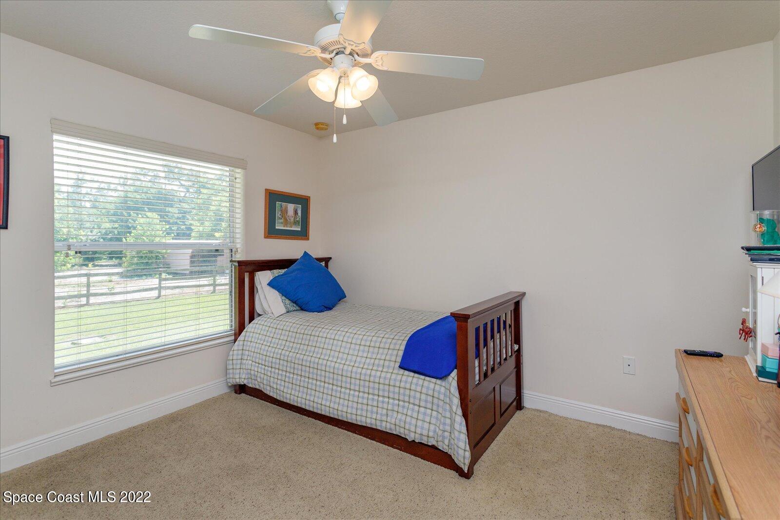 3720 Pine Cone Road Melbourne, FL 32934 - Photo 28 of 34 a bedroom with a large bed and a chandelier