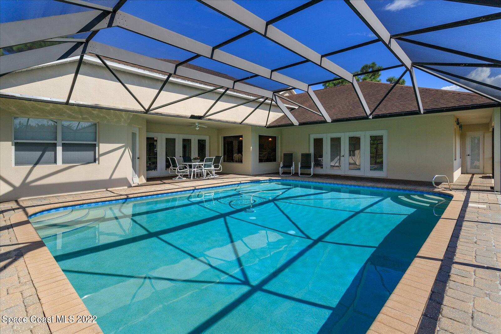 3720 Pine Cone Road Melbourne, FL 32934 - Photo 8 of 34 a view of a patio with a table and chairs under an umbrella